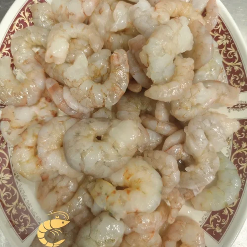 Cola de langostino blanco pelada, fresca y lista para cocinar, presentada en plato decorativo. imagen con el logo de Almar y el lema 'Sabor salvaje, alma atlántica' en la parte inferior.