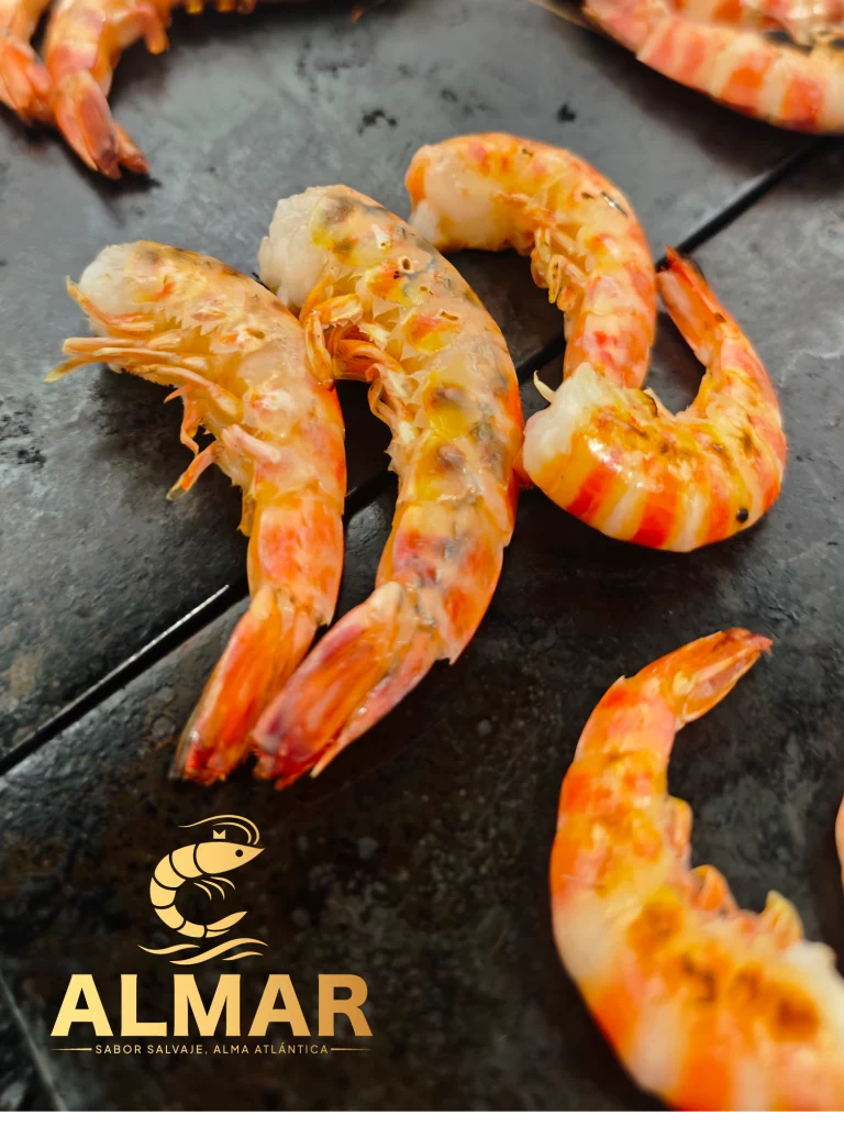 Cola de langostino tigre cocinada a la plancha, con un color dorado y textura jugosa sobre superficie negra. imagen con el logo de Almar y el lema 'Sabor salvaje, alma atlántica' en la parte inferior.